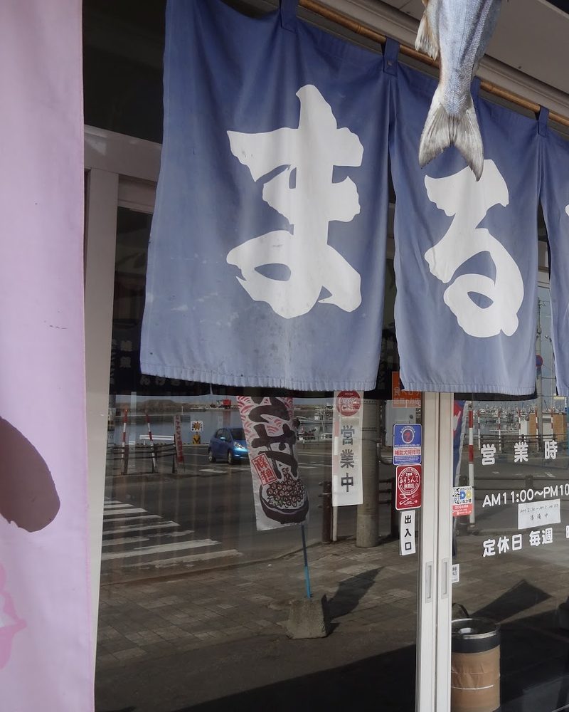 「まるとみ」と染めた紺色ののれん